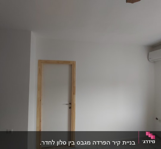 קיר גבס לבן עם דלת עץ ומשקוף